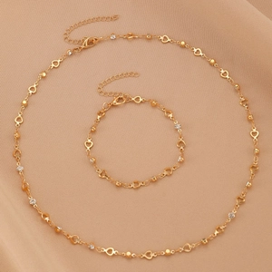 Macro shot of gold heart links and crystal beads on a refined necklace and bracelet set