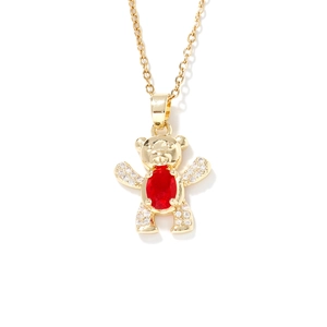 Elegant golden teddy bear necklace with a red oval gemstone pendant on a white background
