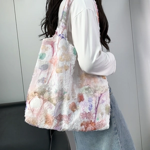 Sac fourre-tout blanc avec broderies florales colorées en relief porté par un mannequin