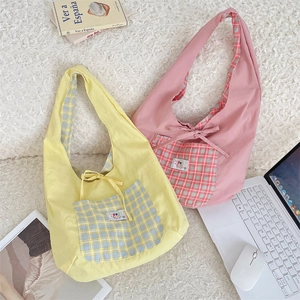 Detail of canvas tote bags with plaid pockets and bows on a cozy lifestyle background