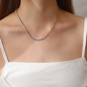 Detail of asymmetrical gold paperclip and silver tennis chain necklace with crystals