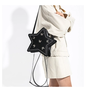 Close-up of black star-shaped crossbody bag with silver studs and butterfly motifs