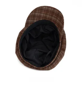 Detailed interior view of a plaid newsboy hat featuring neat black fabric lining
