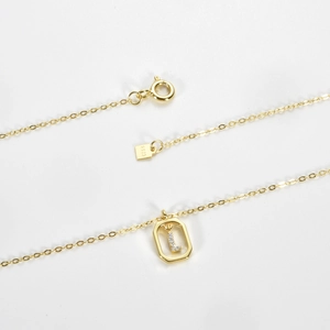 Detail shot of a S925 sterling silver gold-plated pendant necklace featuring a letter L