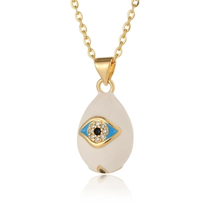 Macro detail of gold evil eye pendant with blue enamel and micro-pave cubic zirconia