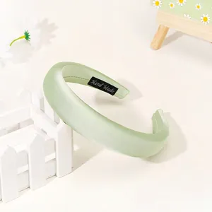 Close-up of mint green padded headband featuring handmade label and silky satin texture
