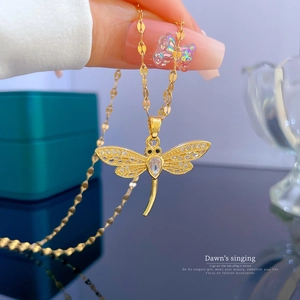 Macro shot of gold-plated dragonfly necklace with cubic zirconia and flat link chain
