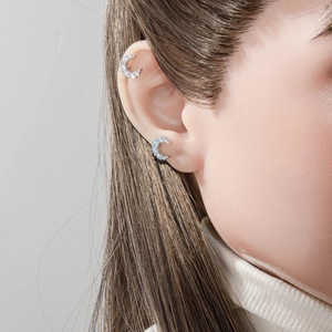 Sparkling silver moon-shaped cartilage earring set with cubic zirconia on a model