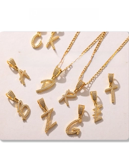 Detailed view of micro-pave zircon letter pendants with electroplated PVD gold finish