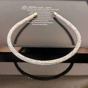Detailed close-up of slim headband with colorful rhinestones and gold protective tips