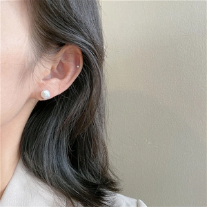 Macro view of minimalist baroque freshwater pearl stud earring on a model's ear