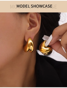 Close-up of gold double-layered teardrop earrings worn by model for elegant style
