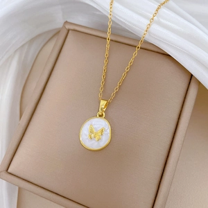 Elegant gold butterfly pendant necklace with white circular base and crystal accents