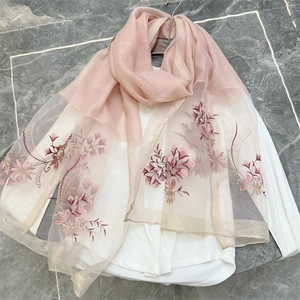 Detail of pink embroidered flowers with gold thread edging on thin blend scarf fabric