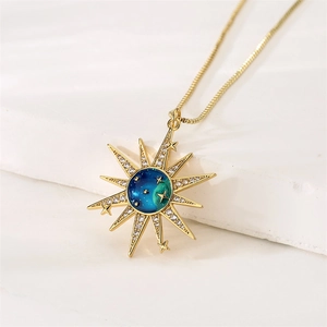 Macro shot of gold sunburst pendant with gradient blue center and micro-paved zircons