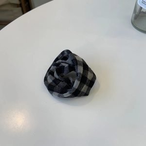 Chic black and white plaid scrunchie with soft pleated fabric texture for hair styling