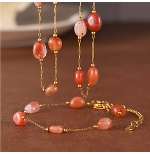 Detail of vintage gold bracelet with oval translucent carnelian stone on leather background