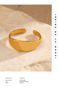 Polished golden wide dome ring with adjustable open band on a natural stone background