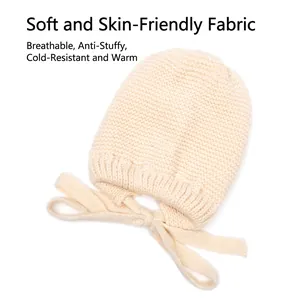 Cream knit baby bonnet with earflaps and chin ties for warm autumn and winter wear