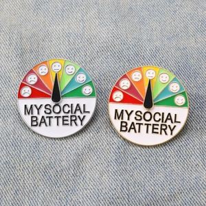 My Social Battery sliding enamel pin in silver and gold on denim fabric background