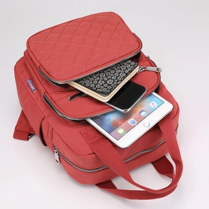 Red quilted nylon backpack with multiple zipper compartments for tablet storage