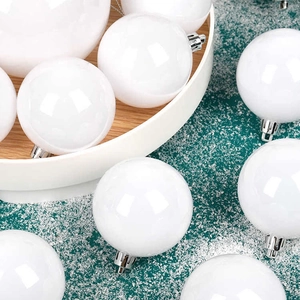 White Christmas ornaments on snowy green background for holiday tree decoration