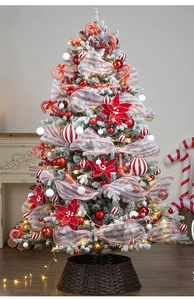 Detail of flocked Christmas tree with red and white ornaments, ribbons, and warm LED lights