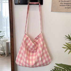 Detailed view of pink and beige checkered canvas tote bag with thick woven texture