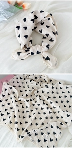 Detail of square beige cotton scarf with black heart print and delicate lace trim