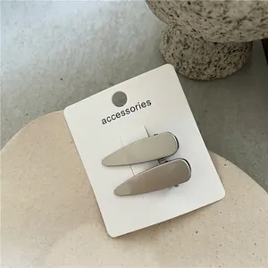 Détail de pinces à cheveux Y2K en métal argenté mat sur plat en céramique avec taille 4,5cm