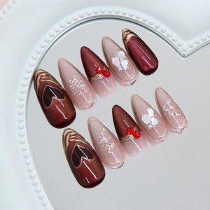Cat eye press-on nails with dark red hearts and pearls on a heart mirror tray