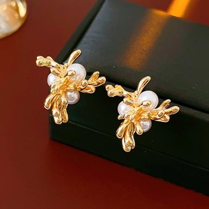 Detailansicht der goldenen Blumenohrringe mit Perlen auf einer schwarzen Schmuckbox