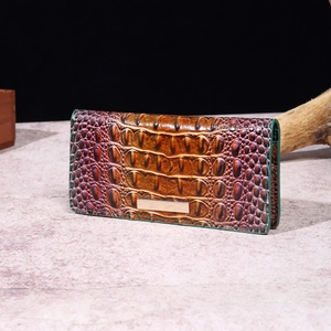 Detail of multi-color crocodile pattern texture on long wallet with metal plaque