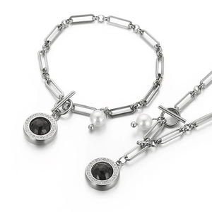 Silver stainless steel jewelry set with black round pendants and white pearls on white background