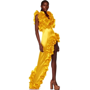 Detail of bright yellow satin gown with asymmetric ruffled hem and V-neckline finish