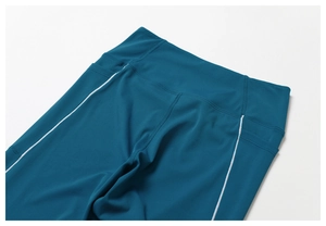 Detalle de mallas de yoga azul marino de cintura alta con bolsillos y rayas blancas