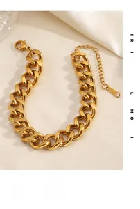 Detail of gold Cuban link bracelet with lobster clasp and S-Steel tag on silk fabric