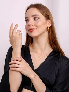 Modèle portant un ensemble collier coeur en nacre plaqué or 18K, boucles et bagues