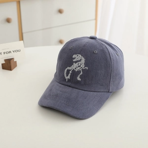 Close-up of dinosaur skeleton embroidery on blue corduroy baseball cap texture