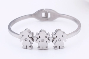 Detail of silver bangle with three girl-shaped pendants featuring clear zircon stones
