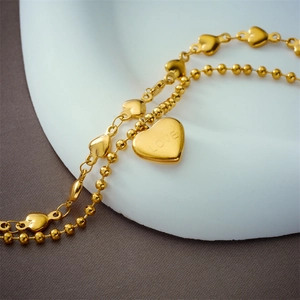 Double-layered gold titanium steel heart bracelet with round beads and LOVE engraving