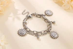 Detail of silver-tone double-layer bracelet with sun pendants and lobster clasp closure