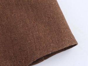 Macro shot of dark brown linen fabric texture with detailed stitching on the hem