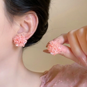 Close-up of model wearing pink crystal cluster tassel earrings with elegant style