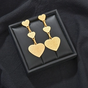 Boucles d'oreilles pendantes triple cœur en or 18 carats avec texture dans un coffret