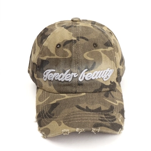 Close-up of distressed brim and Tender Beauty embroidery on camo baseball cap