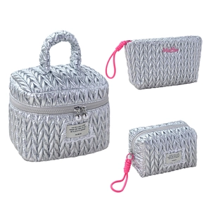 Three-piece silver quilted cosmetic bag set with metallic finish and carry handle