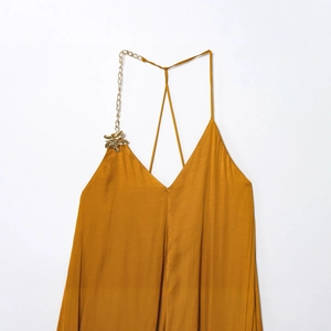 Elegant gold satin midi dress featuring a stylish metal chain strap and luxury star ornament