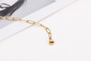 Detail of gold rectangular link chain necklace featuring a secure lobster clasp closure