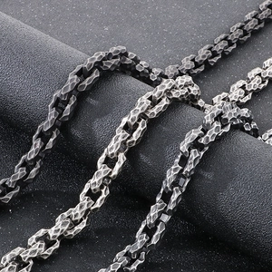 Macro detail of hammered industrial steel chains in silver and gunmetal black finish